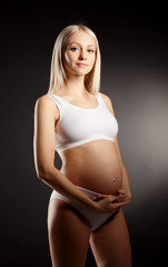 Fototapeta premium Pregnant Woman over dark background