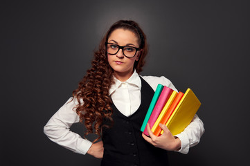 young woman in glasses with pile of books