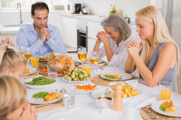 Obraz na płótnie Canvas Rodzina modli się przed obiadem