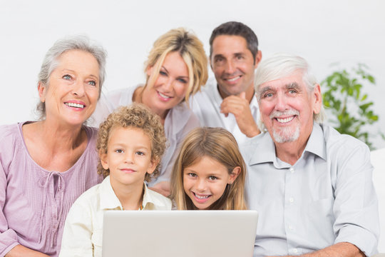 Family Smiling In Front Of A Laptop Screen