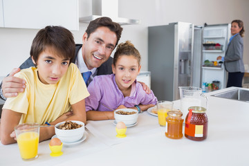 Obraz na płótnie Canvas Uśmiecha się ojciec i dzieci o śniadanie