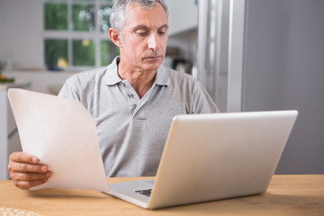 Calm mature man using his laptop