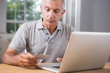 Fototapeta premium Thoughtful mature man using his laptop