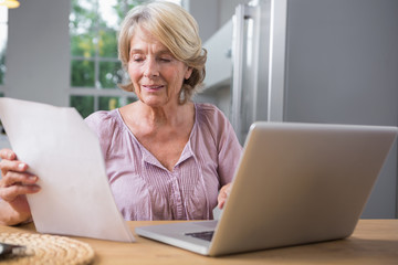 Smiling mature woman using her laptop