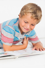 Naklejka premium Happy boy reading a storybook