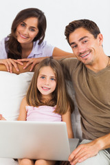 Fototapeta premium Smiling family using the laptop