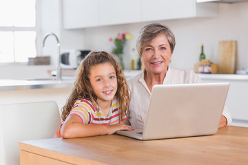 Fototapeta na wymiar Dziecko i babcia, patrząc na kamery z laptopa