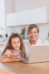 Fototapeta na wymiar Uśmiecha się dziecko i babcia, patrząc na kamery z laptopa