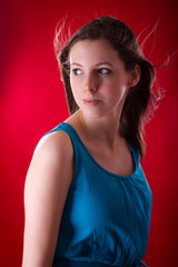 Fototapeta premium Portrait of young beautiful brunette over red background