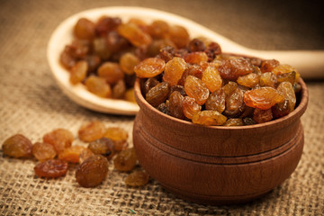 Raisins on a wooden spoon on a burlap