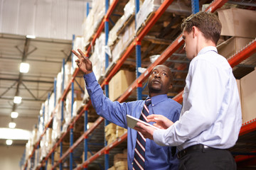 Two Businessmen With Digital Tablet In Warehouse