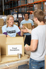 Volunteers Collecting Food Donations In Warehouse