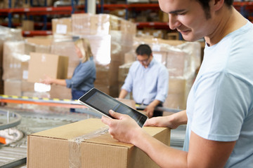 Worker Using Tablet Computer In Distribution Warehouse