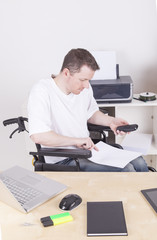 junger Mann im Rollstuhl im Büro