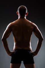 Fototapeta premium Muscular man in dark studio