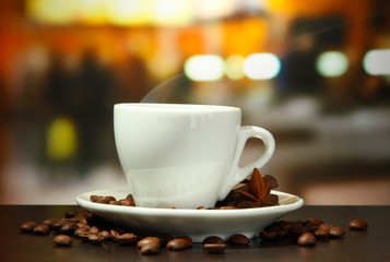 cup of coffee with beans on table in cafe