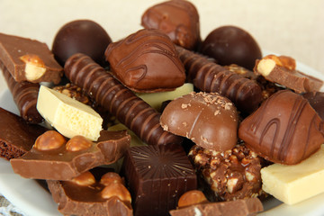 Chocolate and sweets on white plate, close up