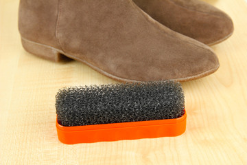 Brush for suede shoes, on wooden background