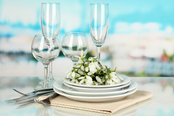 Serving dishes and snowdrops on blue natural background