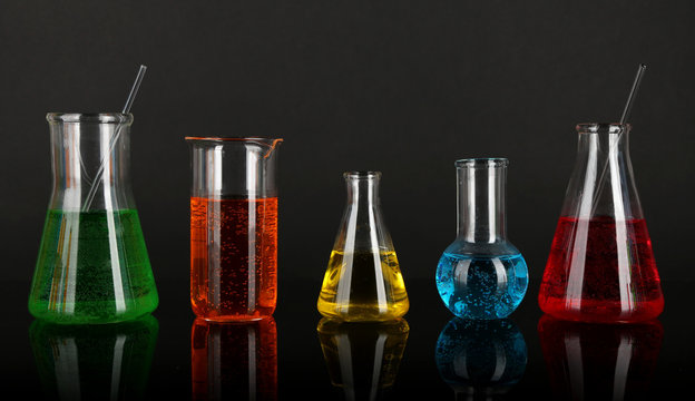 Test tubes with colorful liquids on dark grey background