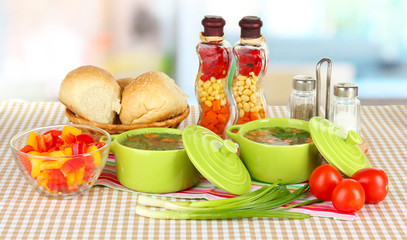 Fragrant soup in pans on table in kitchen