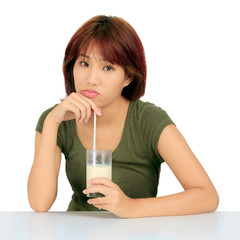 Isolated young asian woman with a glass of milk