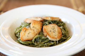 spaghetti with pesto sauce on wood background