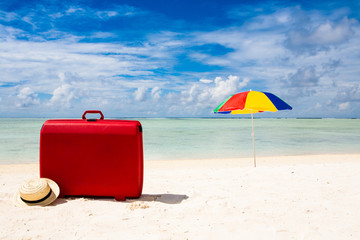 red suitcase at the beach
