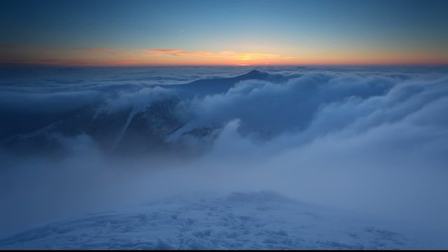 Winter mountain at sunset over clouds - time lapse video