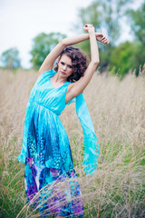 Beautiful woman in blue dress in the field