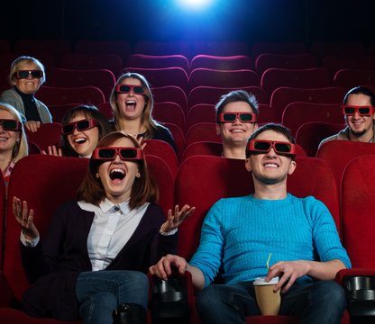 Group of people in 3D glasses watching movie in cinema