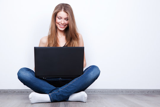 Beautiful Young Woman Sitting On The Floor With Laptop