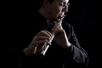 professional flutist musician playing flute on black background © Tommaso Lizzul
