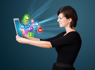 Young woman looking at modern tablet with abstract lights and va
