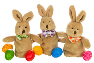 drei Stoffhasen mit bunten Eiern