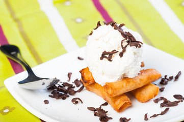 fried leche flan topped with ice cream and chocolate shavings