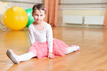 Cute little balerina stretching on floor © spass