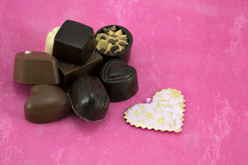 Obraz na płótnie Canvas Assorted Chocolates on pink background.