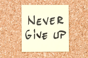 Never Give Up, handwritten on a sticky note