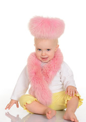 cute baby in pink fur sitting on white background