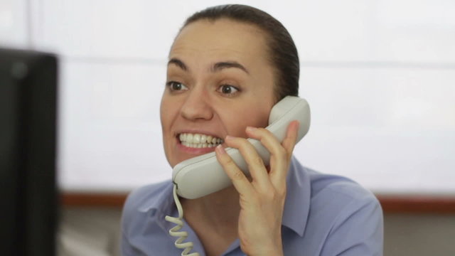 Businesswoman screaming into a phone, close up