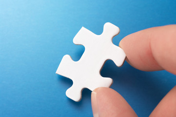 A person picking up one puzzle pieces.