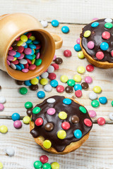 Closeu of muffins with candies and chocolate glaze