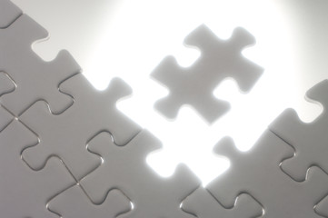 Fitting jigsaw puzzle pieces against the light.