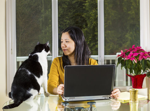 Mature Woman Working At Home Wth Family Looking At Her