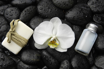 Fototapeta na wymiar White orchid and massage oil ,soap on zen stones background