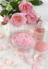 Fototapeta na wymiar Spa setting with pink rose with towel ,salt in bowl, massage oil