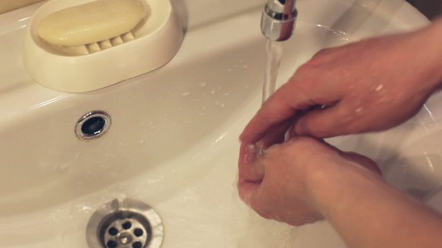 A woman washes her hands with soap closeup