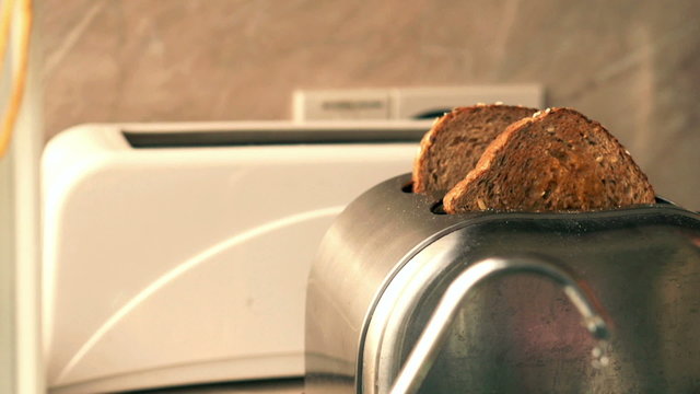 Toasted bread jumps out of the toaster - close up, slow motion s