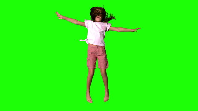Girl jumping up on green screen